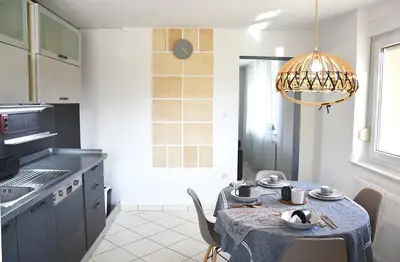 a kitchen with a table and a chandelier at Lesnavesna designer Apartment with a garden in Visoko