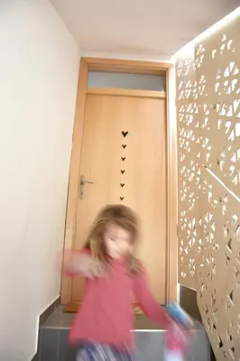 a little girl running in front of a door at Lesnavesna designer Apartment with a garden in Visoko
