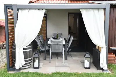 a pergola with a table and chairs on a patio at Zidanica Lan in Lendava
