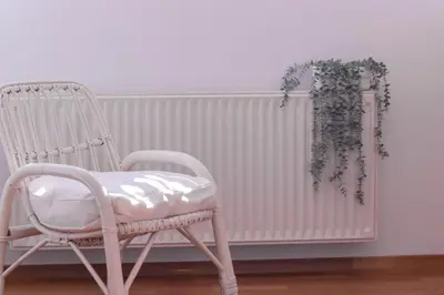 a white rocking chair sitting next to a radiator at Apartment in the heart of Bled with views in Bled