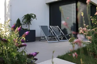 a row of chairs sitting on a patio with flowers at Studio ELITE in Bled