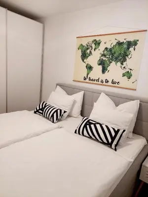 two beds in a room with a map on the wall at Apartment ALMA - to travel is to live in Celje