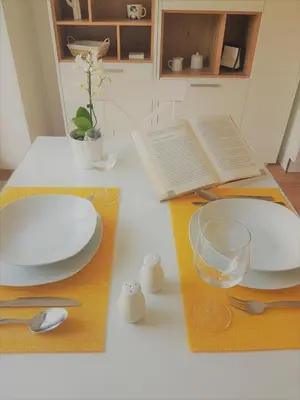 a table with plates and bowls and a laptop at Apartment ALMA - to travel is to live in Celje