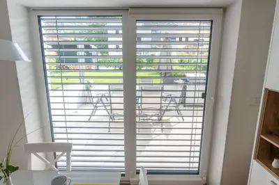 a large window with blinds in a room at Apartment ALMA - to travel is to live in Celje