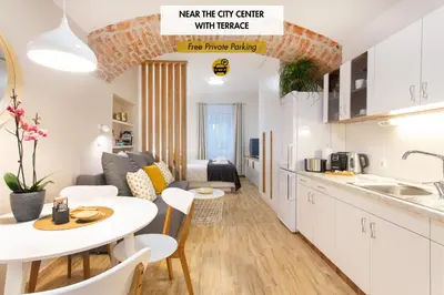 a kitchen and living room with a table and a couch at Apartments Tivoli in Ljubljana