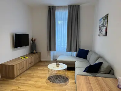 a living room with a couch and a tv at Apartments Tivoli in Ljubljana
