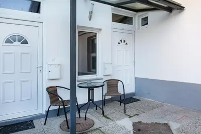 a patio with two chairs and a table and a door at Apartments Tivoli in Ljubljana