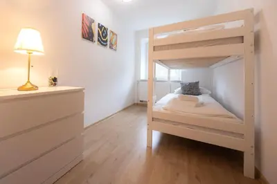 a small bedroom with a bunk bed with a lamp at Grom Ribno Apartments in Bled