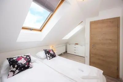 a attic bedroom with a bed and a window at Grom Ribno Apartments in Bled