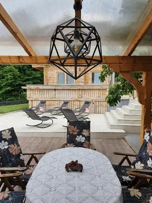 a patio with a table and chairs and a chandelier at Planika Holiday Home in Bled