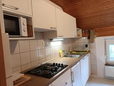a small kitchen with a stove and a microwave at Home away from home in Bohinj