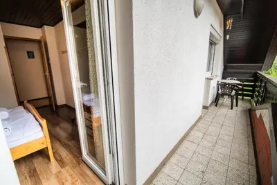 a room with a balcony with a bed and a window at Home away from home in Bohinj