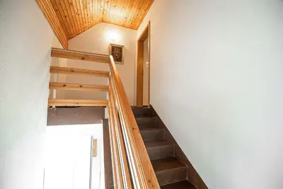 a staircase in a house with a wooden ceiling at Home away from home in Bohinj