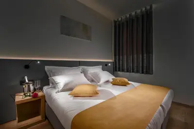 a bedroom with a large bed with two yellow pillows at Hotel Vila Pohorje in Slovenj Gradec