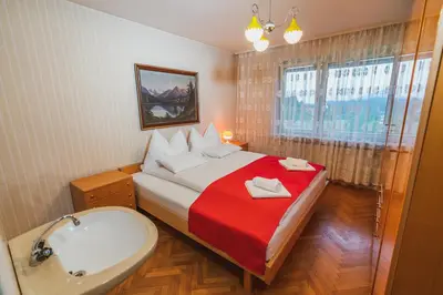 a bedroom with a bed and a tub and a sink at Apartmaji Retro in Spodnje Gorje
