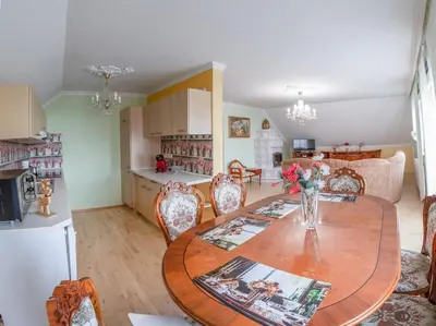 a kitchen and dining room with a table and chairs at APARTMA AJDA in Komenda