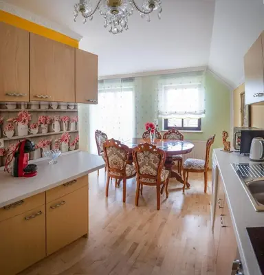 a kitchen with a table and chairs and a dining room at APARTMA AJDA in Komenda