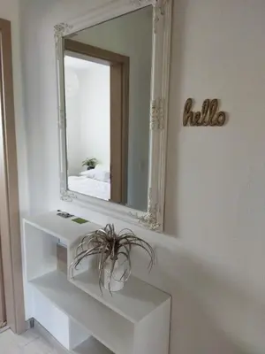 a mirror on a wall next to a white shelf at Apartma JERMAN - Cerknica in Cerknica