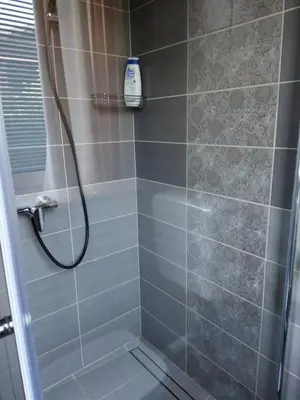 a shower with a shower head in a bathroom at Apartma JERMAN - Cerknica in Cerknica