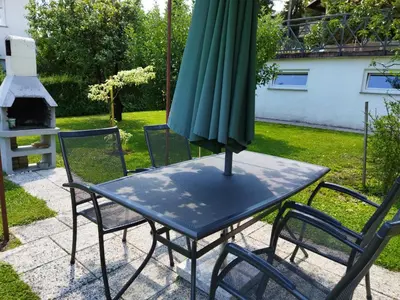 a table with a green umbrella on top of it at Apartma JERMAN - Cerknica in Cerknica