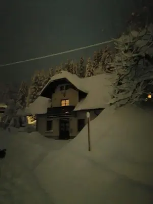 a house with snow on the roof of it at Apartman Irvin in Kranjska Gora
