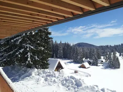 a view of a snow covered mountain with a house at Hotel Jelka Pokljuka in Goreljek