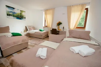 a bedroom with two beds and a living room at Sunny Rooms in Most na Soči