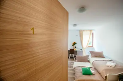 a room with two beds and a door with a number on it at Sunny Rooms in Most na Soči