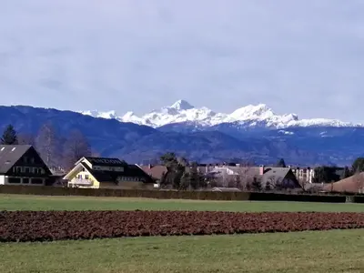 a mountain range with snow capped mountains in the background at edelweiss in Radovljica