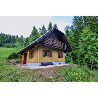a small wooden house in the middle of a field at Počitniška hiša Jeklar in Bohinj
