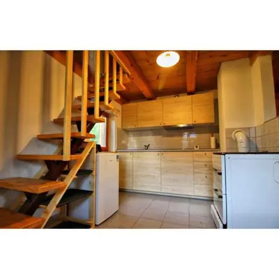a kitchen with wooden cabinets and a staircase in it at Počitniška hiša Jeklar in Bohinj