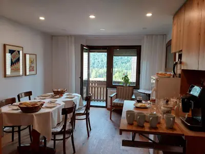 a dining room with a table and a kitchen at SOBE U SIRRC in Bled
