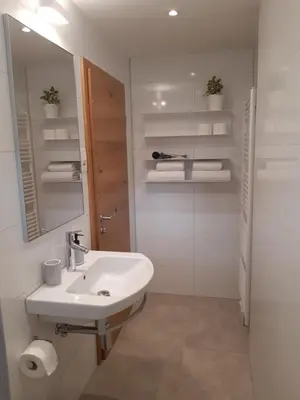 a white bathroom with a sink and a mirror at SOBE U SIRRC in Bled