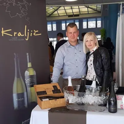 a man and woman standing next to a table with wine bottles at Kraljič - Primož Čotar in Dornberk