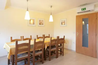 a dining room with a table and wooden chairs at Kraljič - Primož Čotar in Dornberk