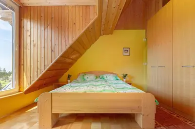 a bedroom with a bed in a room with yellow walls at Koča na Krvavcu in Cerklje na Gorenjskem