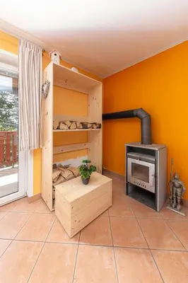 a room with a wood stove in a room at Koča na Krvavcu in Cerklje na Gorenjskem