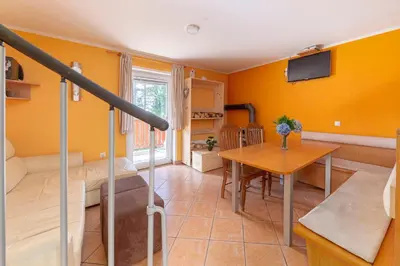 a living room with yellow walls and a table at Koča na Krvavcu in Cerklje na Gorenjskem