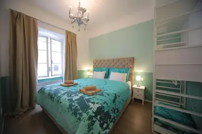 a bedroom with a bed with a blue comforter at Vitez Apartment II in Ljubljana