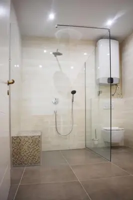 a bathroom with a glass shower with a toilet at Vitez Apartment II in Ljubljana