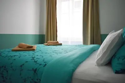 a bedroom with a blue bed with two towels on it at Vitez Apartment II in Ljubljana