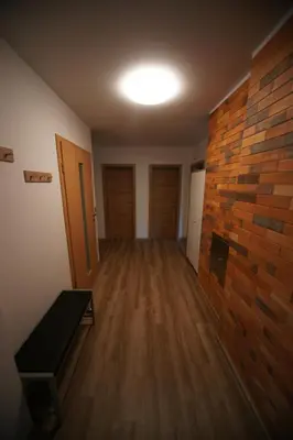 an empty room with a brick wall and wooden floors at Apartment Arh in Bled