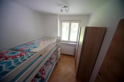 a small bedroom with a bunk bed and a window at Apartment Arh in Bled
