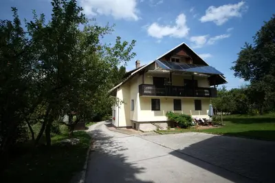 a white house with a porch and a balcony at Apartment Arh in Bled