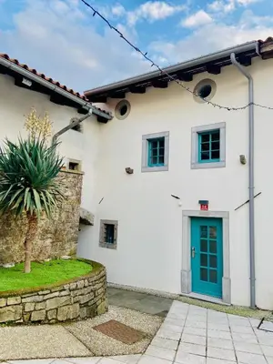 a white house with a blue door at Lagom Home Vipavski Križ in Ajdovščina