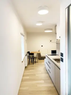 a kitchen and dining room with white walls and wooden floors at Lagom Home Vipavski Križ in Ajdovščina