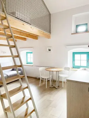 a ladder in a room with a table and chairs at Lagom Home Vipavski Križ in Ajdovščina