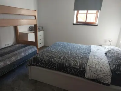 a bedroom with a bed and a wooden bunk bed at APARTMAJI VITEZ apartma 1 in Bovec