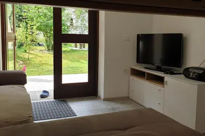 a living room with a flat screen tv and a window at APARTMAJI VITEZ apartma 1 in Bovec