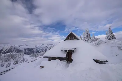a house covered in snow on a mountain at Koča Zlatorog - Velika planina in Stahovica